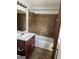Bathroom featuring tiled shower with safety bar, brown vanity with sink, and a mirror at 2195 Wilson Nw Rd, Conyers, GA 30012