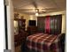 Bedroom with a plaid bedspread, ceiling fan, dresser, and red accent curtains in a cozy setting at 2195 Wilson Nw Rd, Conyers, GA 30012