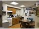 Kitchen featuring wooden cabinets, laminate countertops, white appliances, and a table with wooden chairs at 2195 Wilson Nw Rd, Conyers, GA 30012