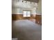 Spacious living room featuring carpet, wood paneling, and a bright window for natural light at 2195 Wilson Nw Rd, Conyers, GA 30012