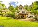 Lush green backyard with mature trees and a covered patio, perfect for outdoor living at 130 Brooklet Way, Brooks, GA 30205