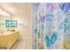 Bright bathroom featuring a beach-themed shower curtain and yellow vanity at 130 Brooklet Way, Brooks, GA 30205
