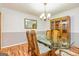 Beautiful dining room boasts a glass table, wood flooring, and a stylish display cabinet at 130 Brooklet Way, Brooks, GA 30205
