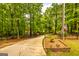 Gated driveway surrounded by mature trees leads to a secluded property with an American flag at 130 Brooklet Way, Brooks, GA 30205