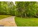 Scenic driveway leading through lush greenery and mature trees to the property at 130 Brooklet Way, Brooks, GA 30205