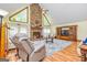 Spacious living room with a stone fireplace, vaulted ceilings, and large windows for natural light at 130 Brooklet Way, Brooks, GA 30205