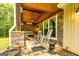 Cozy covered porch features stone accents, rocking chairs, and a wood-paneled ceiling for relaxing outdoors at 130 Brooklet Way, Brooks, GA 30205