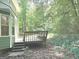 Backyard featuring a wooden deck surrounded by lush trees, creating a peaceful and inviting outdoor space at 305 Glenloch Ln, Stockbridge, GA 30281