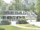 Beautiful two-story home with a front porch and a two-car garage, nestled amongst trees at 305 Glenloch Ln, Stockbridge, GA 30281