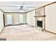 Spacious living room includes a stone fireplace, ceiling fan and bright windows at 305 Glenloch Ln, Stockbridge, GA 30281