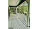 Side porch with white wood floors and railings offer a pleasant view of the surrounding greenery at 305 Glenloch Ln, Stockbridge, GA 30281