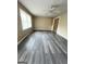 Bright living room featuring new gray flooring, neutral walls, ceiling fan and large windows at 229 Timberland Trl, Riverdale, GA 30274