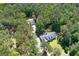 Aerial view of a charming home surrounded by lush greenery, with a detached garage and ample yard space at 3499 S Ola Rd, Locust Grove, GA 30248