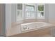 Elegant soaking tub with white tile surround and a bay window view at 3499 S Ola Rd, Locust Grove, GA 30248