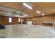 Large garage with exposed wood walls, concrete floors and fluorescent lighting; perfect for hobbies or workshop at 3499 S Ola Rd, Locust Grove, GA 30248