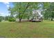 View of the backyard with a wooden deck and mature trees at 1704 New Hope Rd, Locust Grove, GA 30248