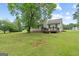 Scenic view of the backyard with a wooden deck and lush green lawn at 1704 New Hope Rd, Locust Grove, GA 30248