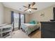 Cozy bedroom with a ceiling fan, a bed with teal pillows, and a bright window view at 1704 New Hope Rd, Locust Grove, GA 30248