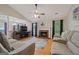 Inviting living room featuring a cozy brick fireplace, ceiling fan, and hardwood floors at 1704 New Hope Rd, Locust Grove, GA 30248