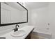 Bright bathroom features a bathtub and a sink with a dark trim mirror at 1823 Devon Sw Dr, Atlanta, GA 30311