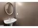 Small powder room with pedestal sink and modern round mirror at 1823 Devon Sw Dr, Atlanta, GA 30311