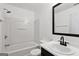 This bathroom features a shower-tub combo and a black framed mirror at 1823 Devon Sw Dr, Atlanta, GA 30311