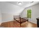 A bedroom with hardwood floors, a window view of the backyard, and an empty bed frame at 2058 Sewanee Ct, Villa Rica, GA 30180