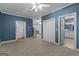 Carpeted bedroom with ensuite bathroom, ceiling fan and access to storage closets at 2058 Sewanee Ct, Villa Rica, GA 30180