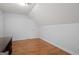 A bright bedroom with hardwood floors, a desk, and white walls with a built-in attic door at 2058 Sewanee Ct, Villa Rica, GA 30180