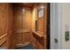 Interior view of residential elevator featuring paneled wood construction and an easy-to-use control panel at 2058 Sewanee Ct, Villa Rica, GA 30180