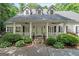 Welcoming front porch with white columns, dual ceiling fans, and lush landscaping at 2058 Sewanee Ct, Villa Rica, GA 30180
