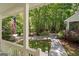 Inviting front porch view featuring lush landscaping and a glimpse of the driveway and the American Flag at 2058 Sewanee Ct, Villa Rica, GA 30180