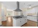 Open concept kitchen with island seating, stainless hood, and white cabinets at 2058 Sewanee Ct, Villa Rica, GA 30180