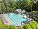 This aerial shows a spacious community pool with trees, umbrellas and lounge chairs ready for summer fun at 11255 Wittenridge Dr, Alpharetta, GA 30022