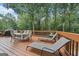 Spacious back deck with lounge chairs, a dining set, and tranquil wooded scenery at 480 Holly Hills Ln, Mcdonough, GA 30252
