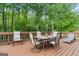Relaxing back deck features outdoor seating with a view of a lush, wooded backyard at 480 Holly Hills Ln, Mcdonough, GA 30252