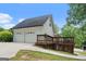 Exterior view with a two-car garage and a wooden deck; serene environment with mature trees at 480 Holly Hills Ln, Mcdonough, GA 30252