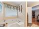 Bathroom featuring a soaking tub with decorative sconces and neutral color scheme at 480 Holly Hills Ln, Mcdonough, GA 30252