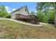Exterior view with a two-car garage and a wooden deck; serene environment with mature trees at 480 Holly Hills Ln, Mcdonough, GA 30252