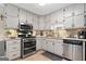Modern kitchen features stainless steel appliances, white cabinets and stone countertops at 480 Holly Hills Ln, Mcdonough, GA 30252