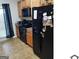 Functional kitchen featuring black appliances, tile backsplash and cabinets with dark countertops at 547 Se Tufton Se Trl, Atlanta, GA 30354