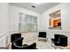 Bright living room area with white walls, black velvet chairs and a pass through to the kitchen at 547 Se Tufton Se Trl, Atlanta, GA 30354