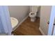 Compact powder room with a pedestal sink, toilet, and wood-look vinyl flooring at 547 Se Tufton Se Trl, Atlanta, GA 30354
