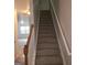 Carpeted staircase leading upstairs, with a light-colored railing and freshly painted walls at 547 Se Tufton Se Trl, Atlanta, GA 30354