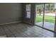 Living room with tile floors, a bright window and sliding door view to green backyard at 6260 Marbut Farms Ter, Lithonia, GA 30058