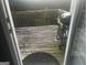 Shows the back deck with a grill, wooden railing and a view of the trees from the doorway looking out at 10937 Southwood Dr, Hampton, GA 30228