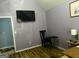 Bedroom with mounted TV, open doorway, and black chair at 10937 Southwood Dr, Hampton, GA 30228