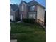 View of the two-story brick home showcasing the front lawn and side wooden staircase at 10937 Southwood Dr, Hampton, GA 30228
