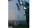 Shows the side of the home with light siding, white trim, and a partial view of the home's lush yard at 10937 Southwood Dr, Hampton, GA 30228