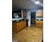 Traditional kitchen with wooden cabinets, dark countertops, and view to the dining area at 10937 Southwood Dr, Hampton, GA 30228